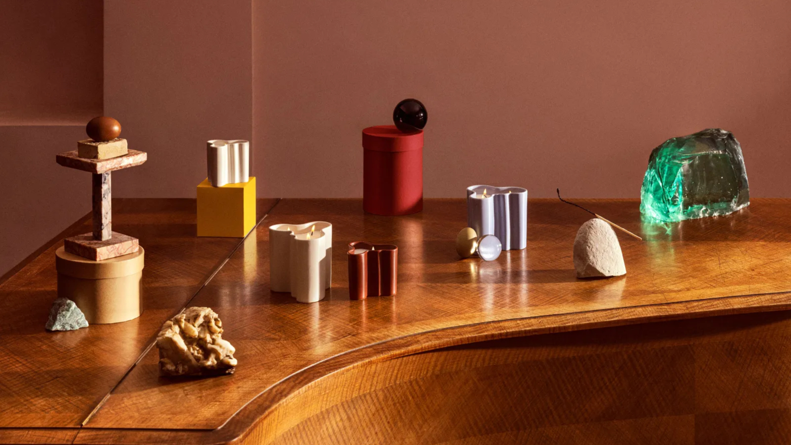 colourful candle holders arranged across a piano top